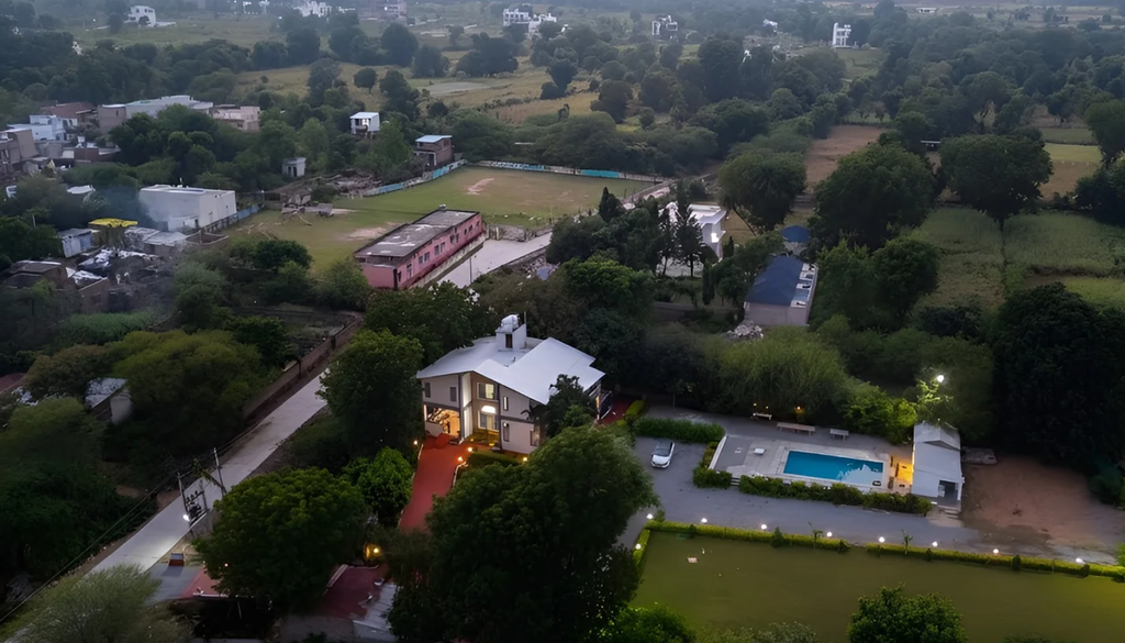 villa exterior with private pool, lit up for an evening party